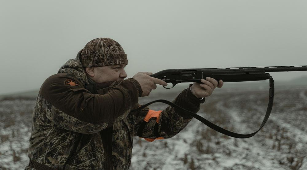 Man in camo getting ready to shoot his shotgun in the hunting area of Rend Lake in Southern Illinois